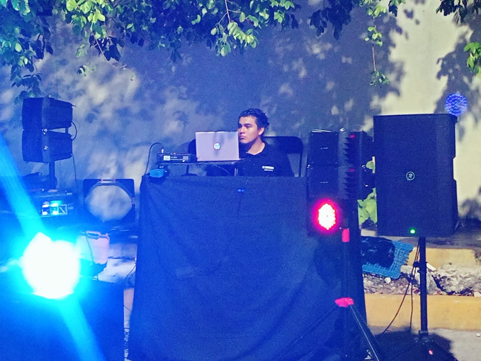Cabina de DJ con bocinas y luces en un evento nocturno