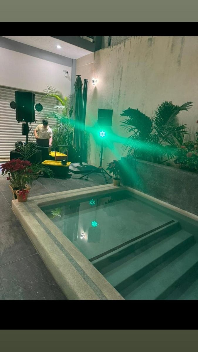 Iluminación verde junto a una alberca en un evento
